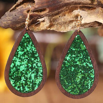 a pair of wooden earrings with green glitter