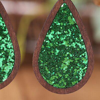 a pair of wooden earrings with green glitter