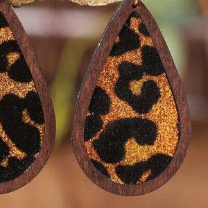 a pair of brown and black earrings hanging from a tree