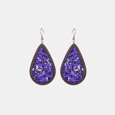 a pair of earrings with purple glitter on them