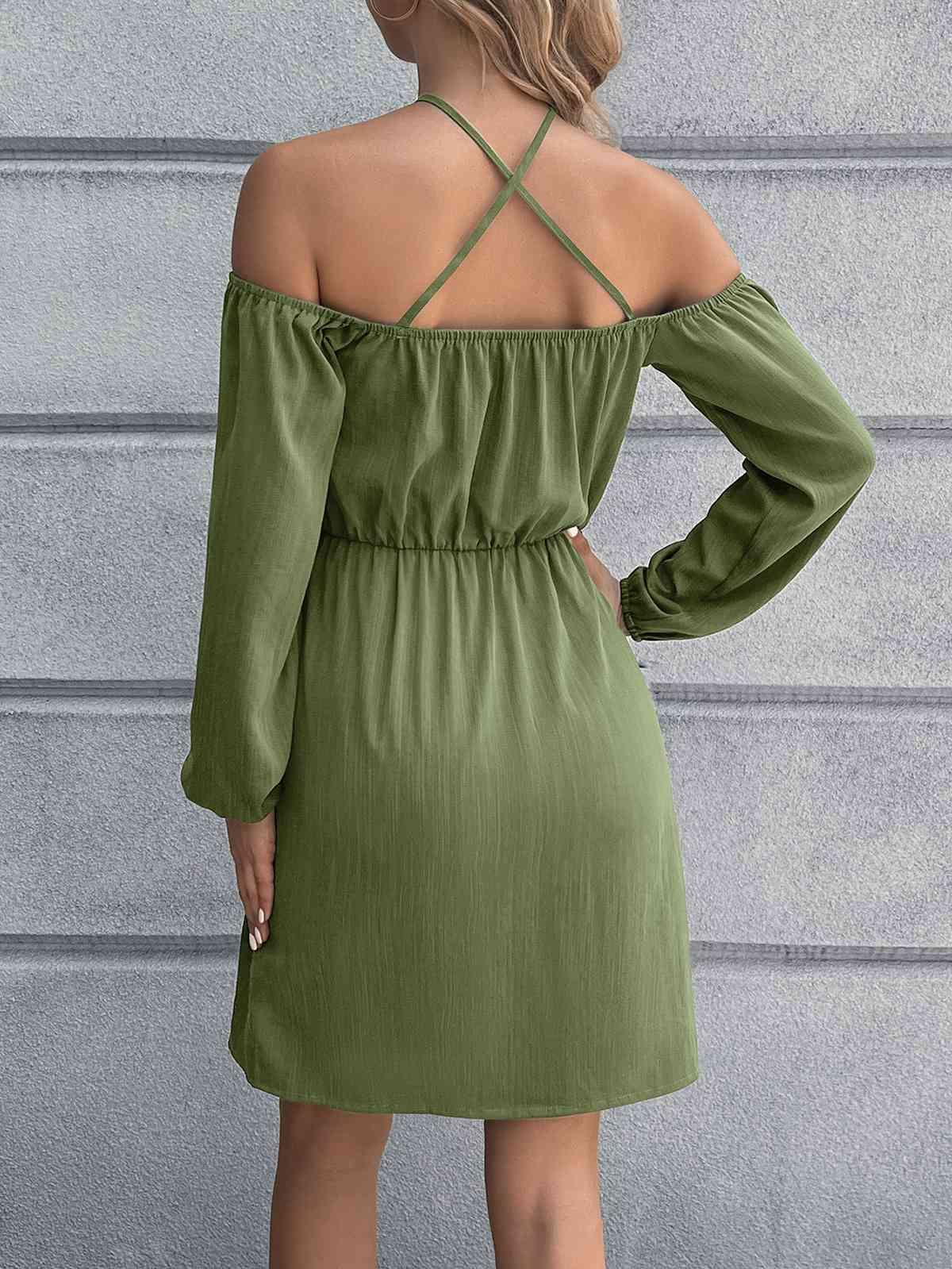 a woman wearing a green dress with a cross back