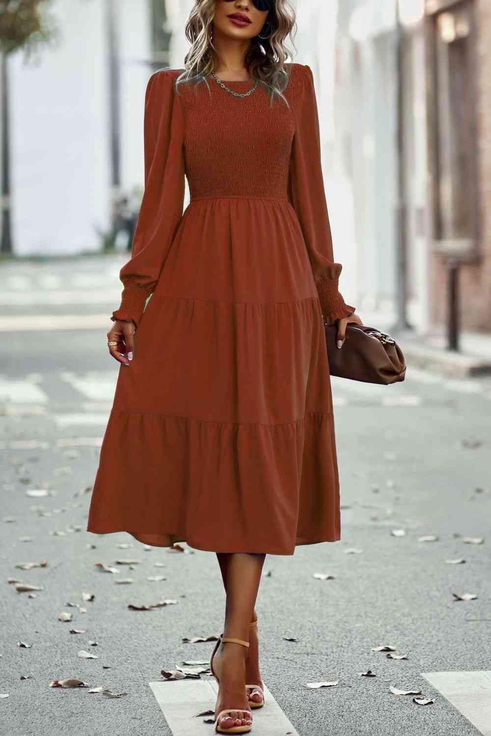 a woman in a brown dress is walking down the street