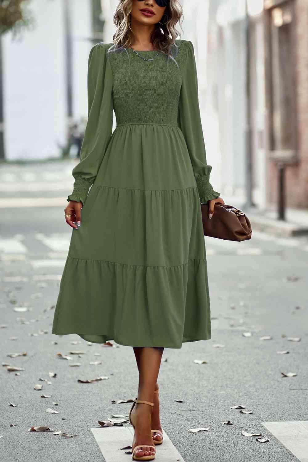 a woman in a green dress is walking down the street