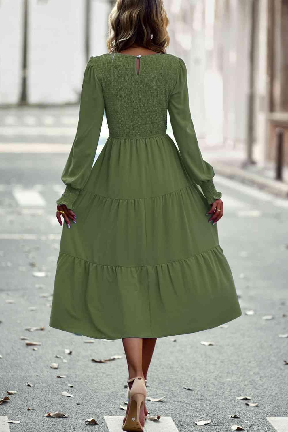 a woman in a green dress is walking down the street