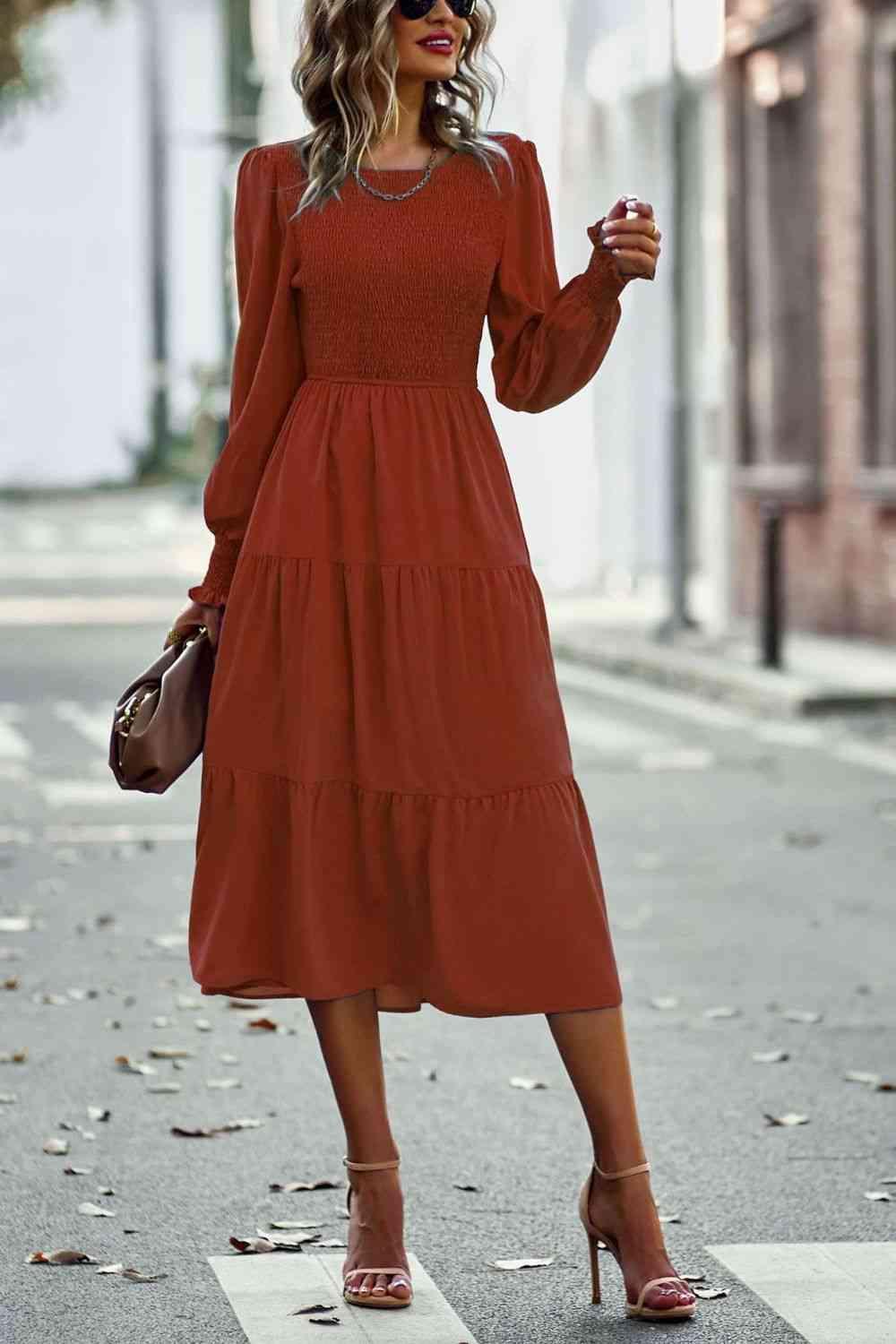 a woman in a red dress is standing on the street