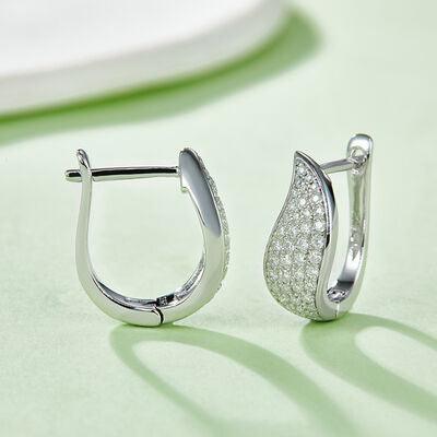 a pair of diamond earrings sitting on top of a table