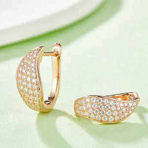 a pair of diamond earrings on a table