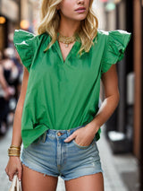 a woman in a green shirt and denim shorts