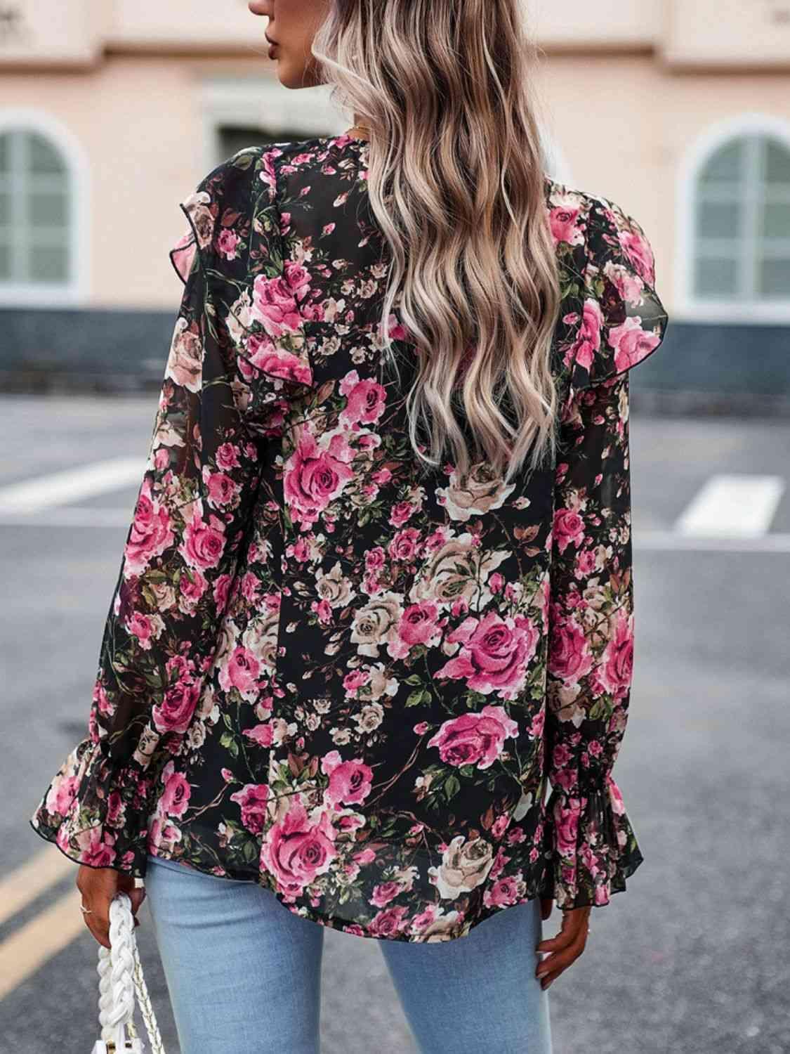 a woman wearing a floral blouse and jeans