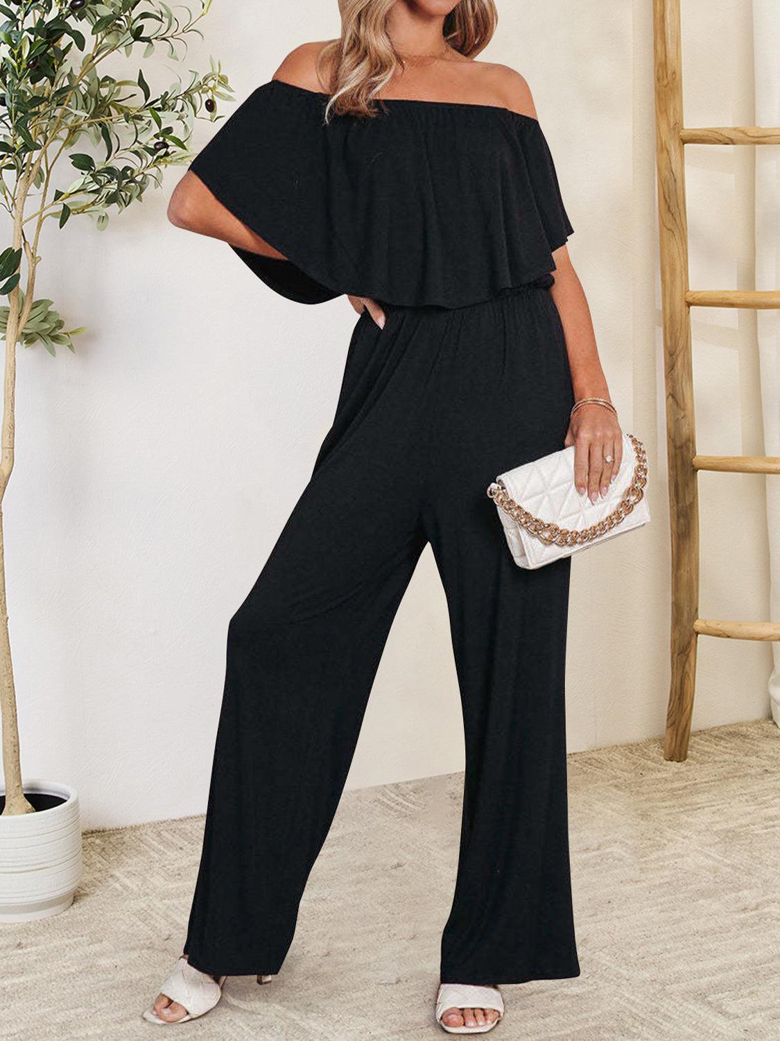 a woman in a black jumpsuit posing for a picture