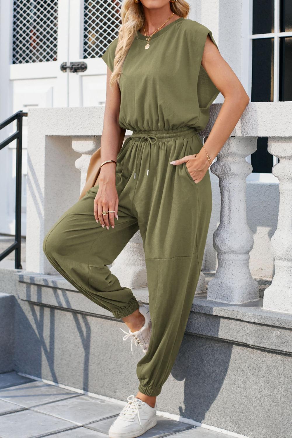 a woman in a green jumpsuit posing for the camera