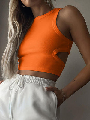 a woman wearing an orange crop top and white shorts