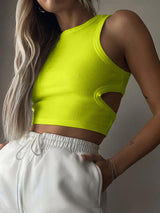 a woman wearing a yellow crop top and white shorts