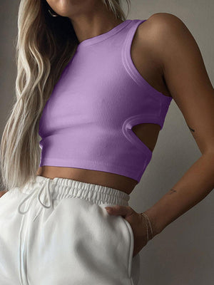 a woman wearing a purple crop top and white shorts