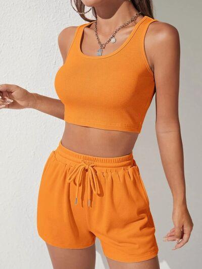 a woman wearing an orange crop top and shorts