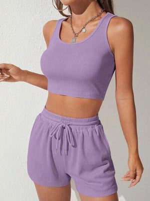 a woman wearing a purple crop top and shorts