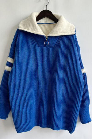 a blue sweater hanging on a hanger