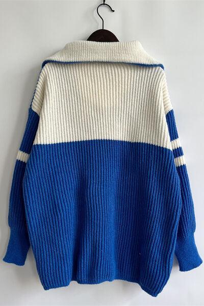 a blue and white sweater hanging on a hanger