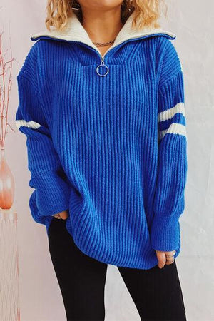 a woman wearing a blue sweater and black pants