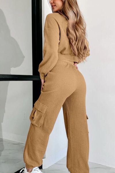 a woman wearing a brown jumpsuit and white sneakers