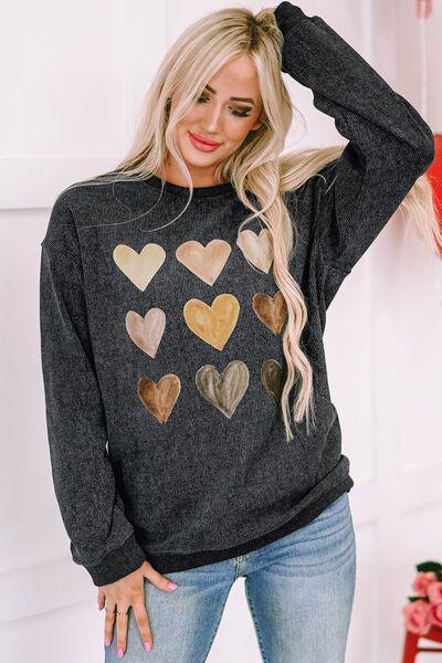 a woman wearing a sweater with hearts on it