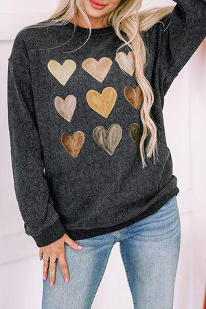 a woman wearing a sweater with hearts on it