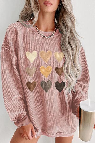 a woman wearing a pink sweater with hearts on it