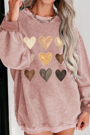 a woman wearing a pink sweater with hearts on it