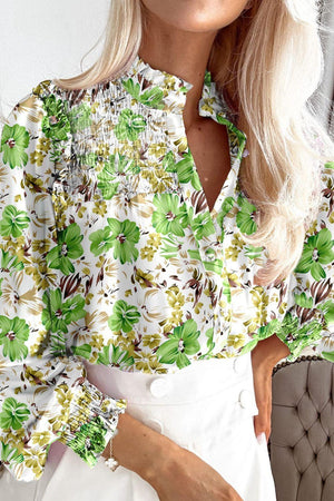 a woman wearing a floral shirt and white skirt