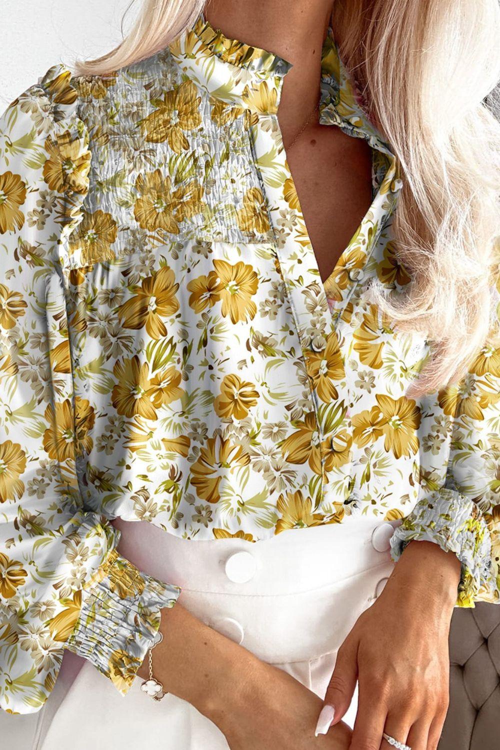 a woman with blonde hair wearing a floral blouse