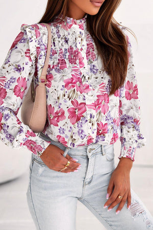 a woman wearing a floral shirt and jeans