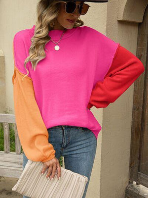 a woman wearing a pink and orange sweater
