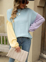 a woman wearing a blue and yellow sweater and jeans