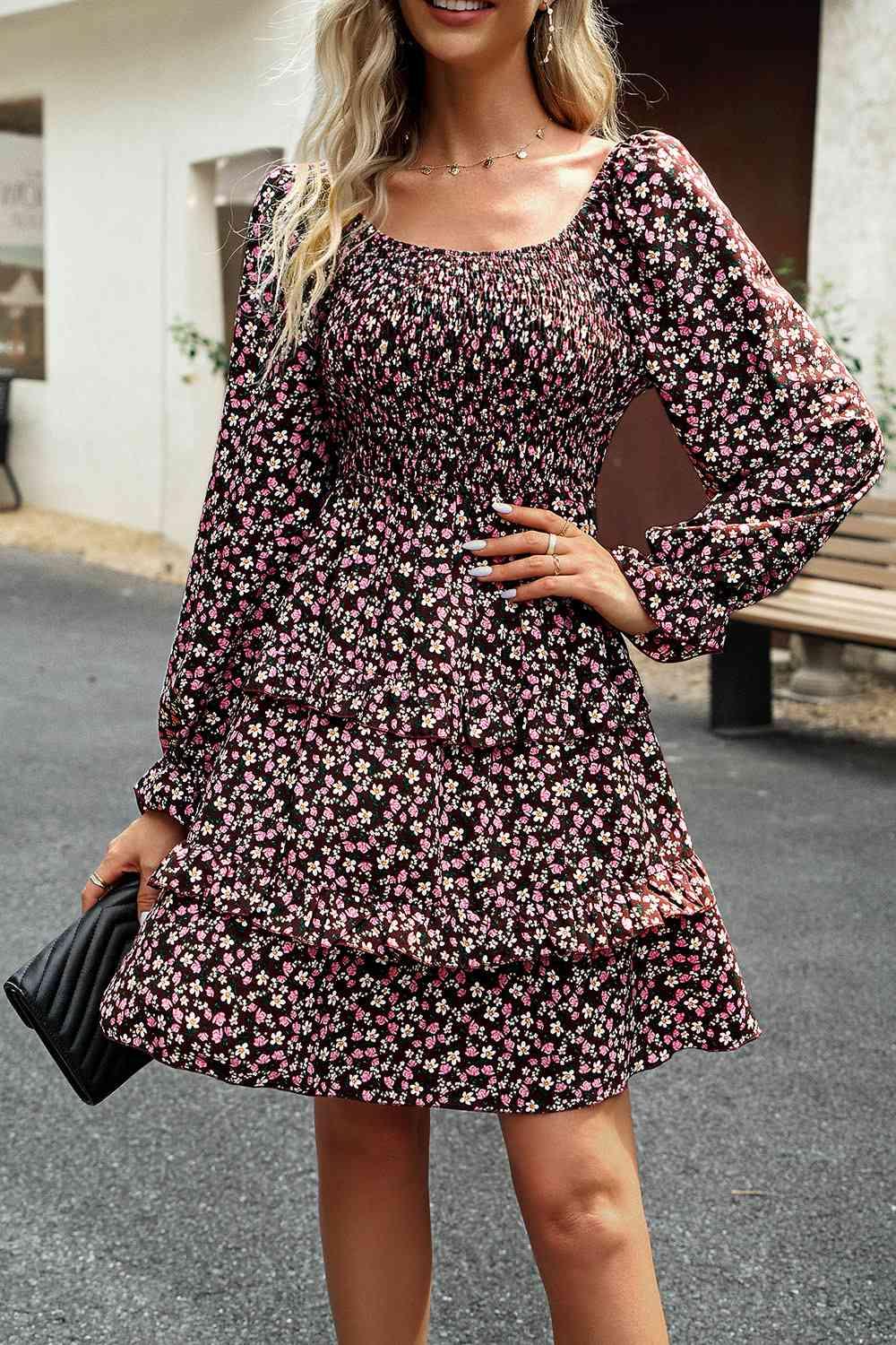 a woman wearing a black and pink floral dress