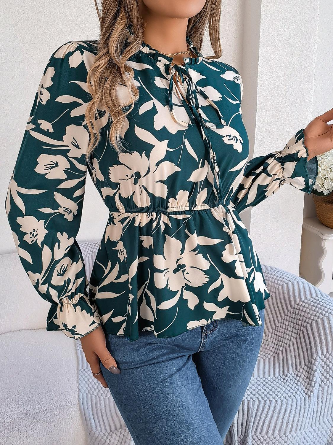 a woman wearing a green floral blouse and jeans