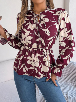 a woman in a floral blouse holding a cell phone