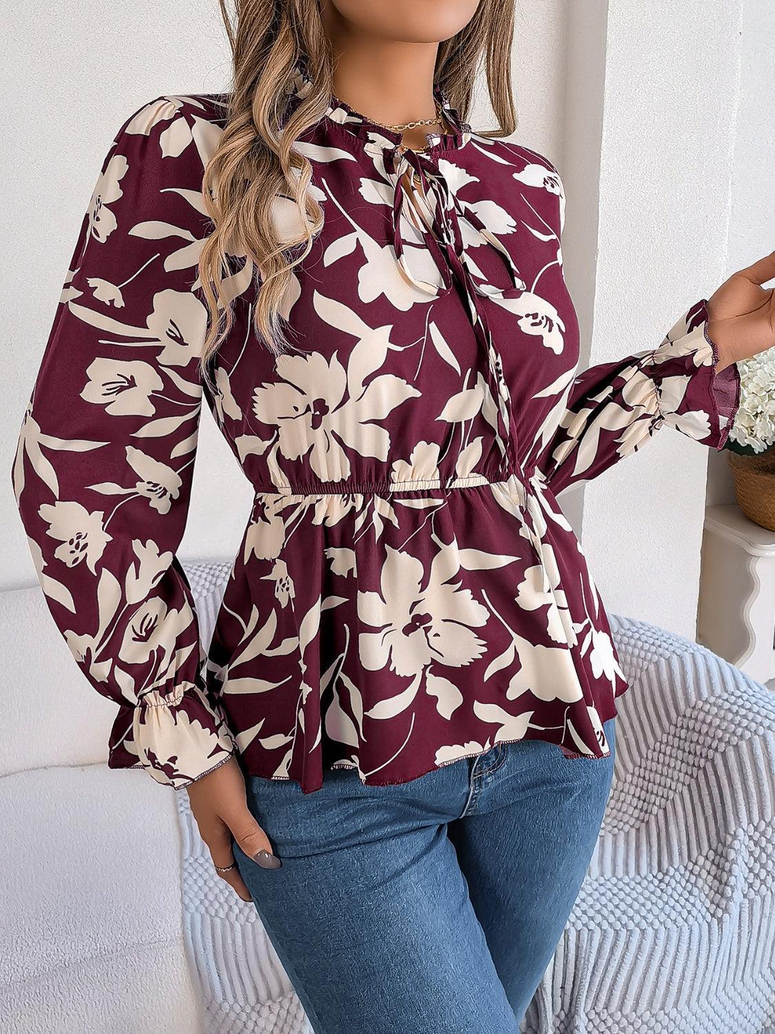 a woman in a floral blouse posing for a picture