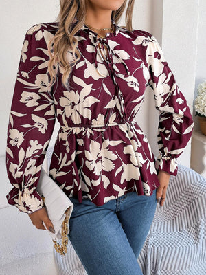 a woman wearing a floral blouse and jeans