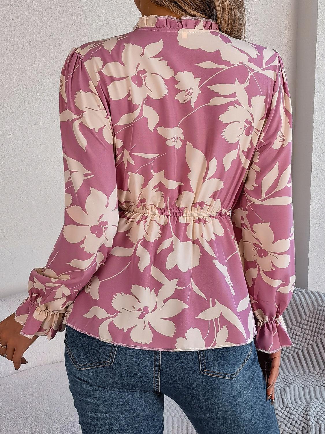 a woman wearing a pink floral blouse and jeans