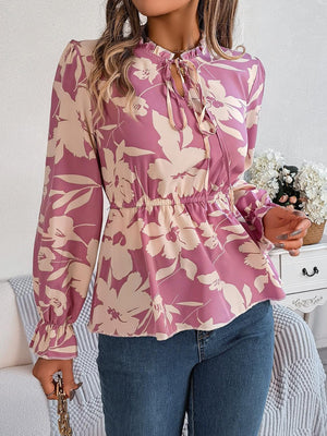 a woman wearing a pink floral blouse holding a bouquet of flowers