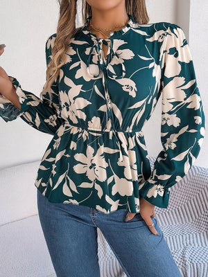 a woman wearing a green and white floral blouse