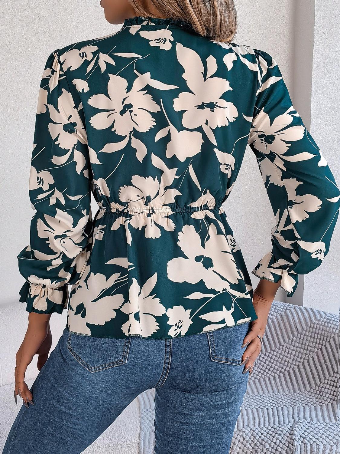 a woman wearing a green floral blouse and jeans