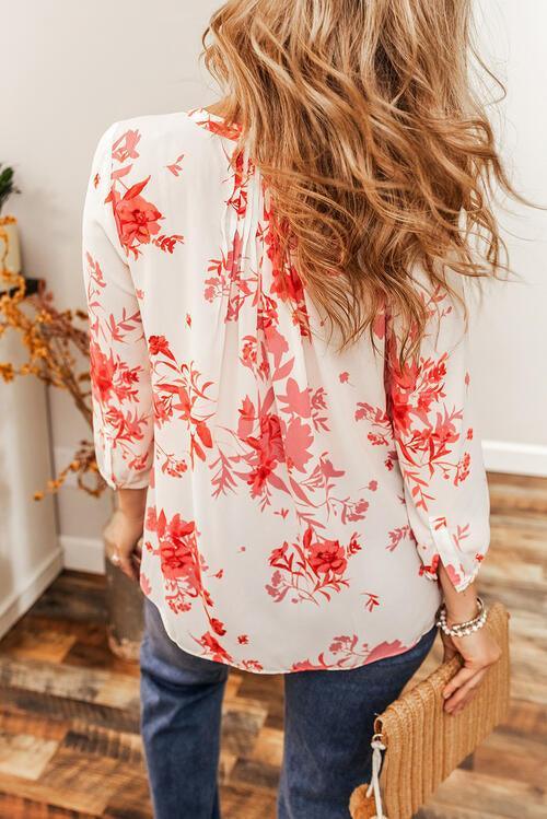 a woman with long hair wearing a floral blouse