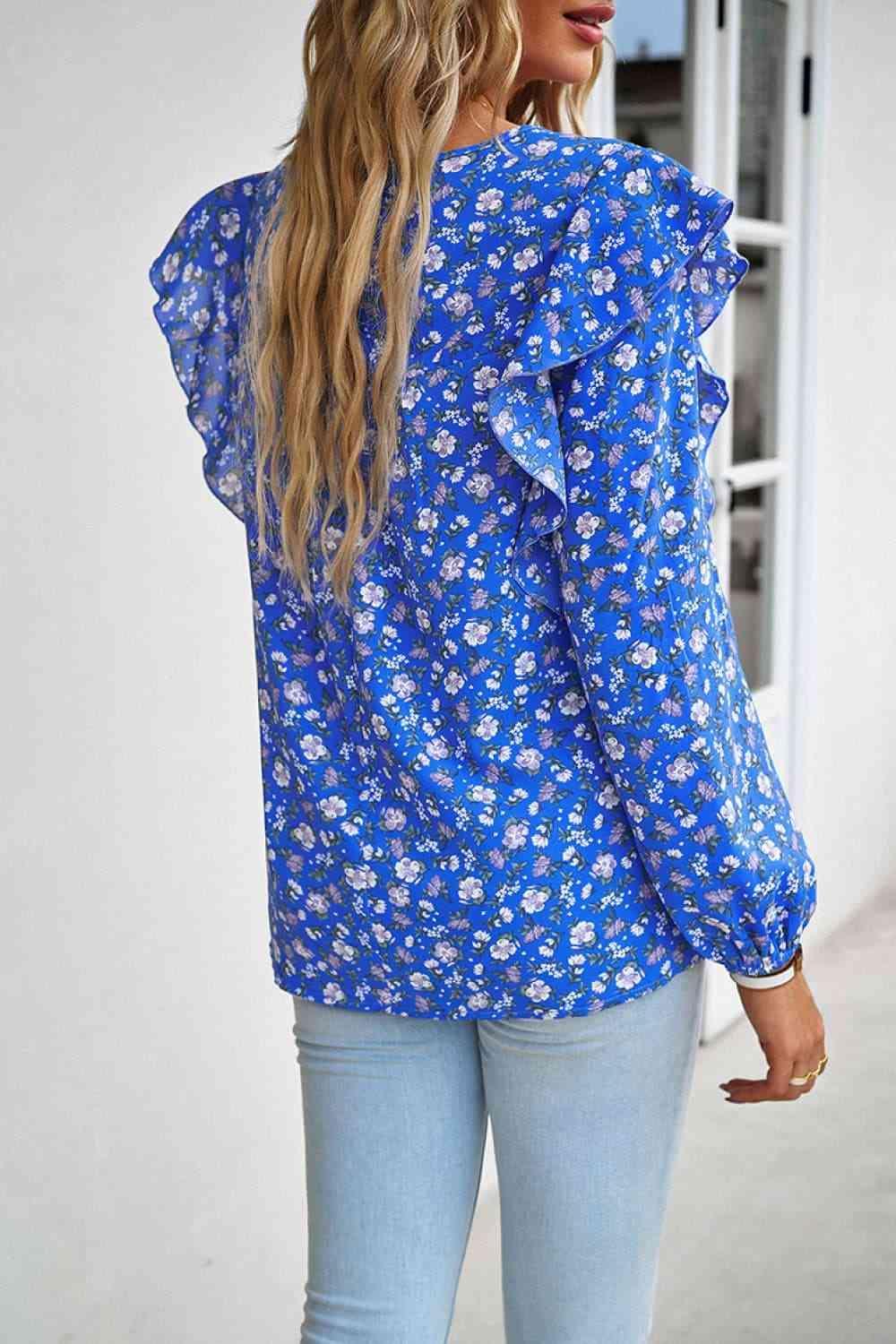 a woman wearing a blue floral blouse and jeans