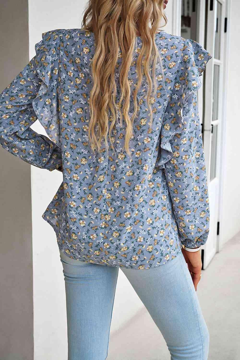 a woman wearing a blue floral blouse and jeans