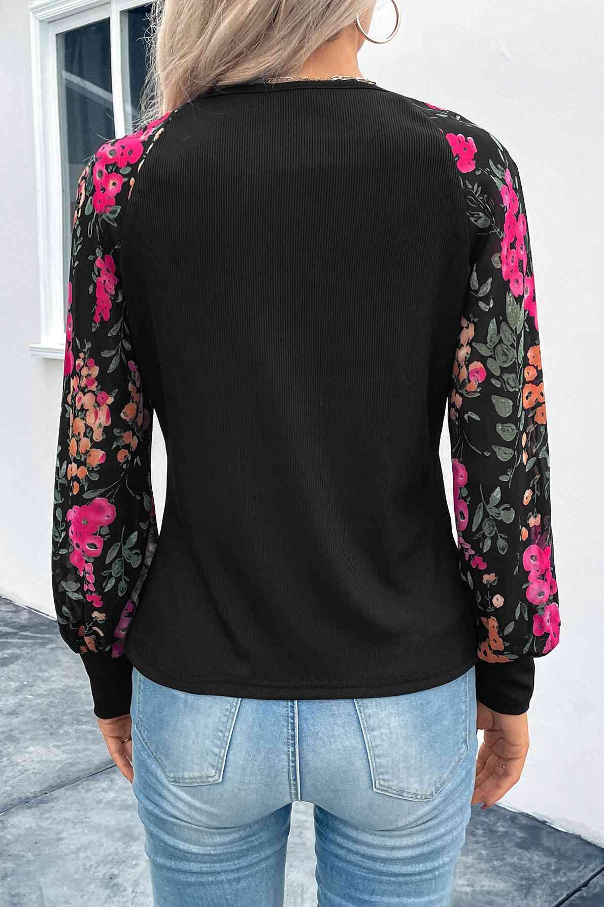 a woman wearing a black top with pink flowers on it