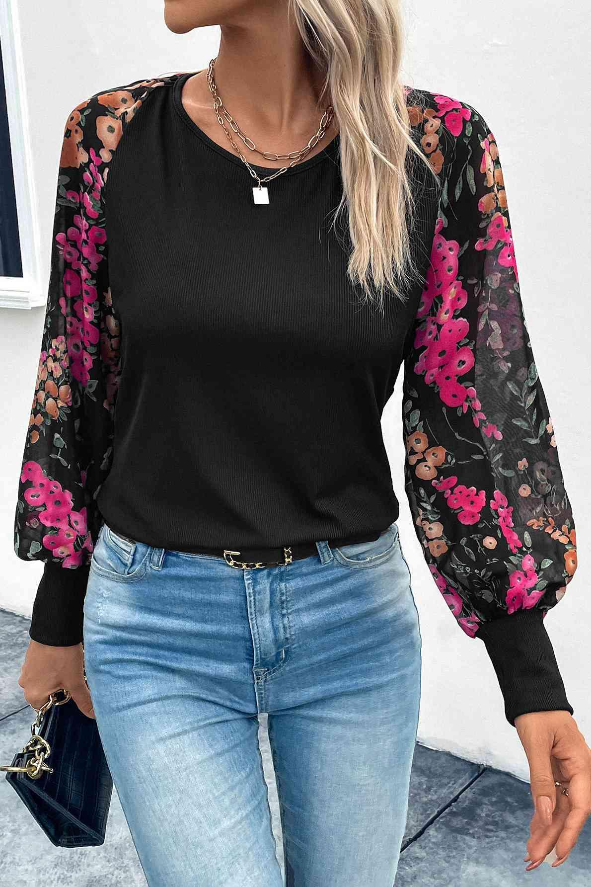 a woman wearing a black top with pink flowers on it