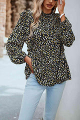 a woman wearing a black and yellow floral blouse