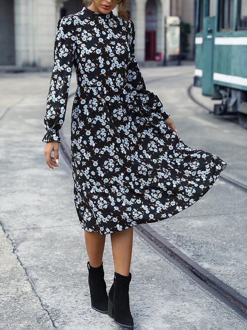 a woman wearing a black and white floral dress