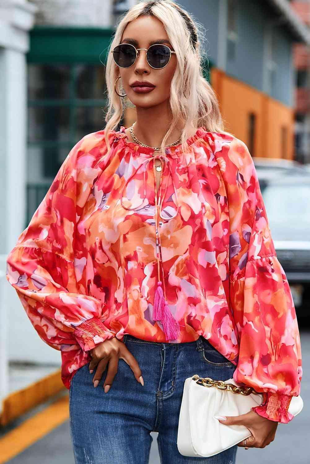 a woman with blonde hair wearing a pink blouse and jeans